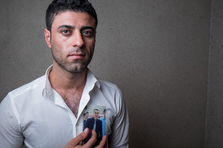 A picture of Sinan holding a photo of his friend recently killed by ISIS
