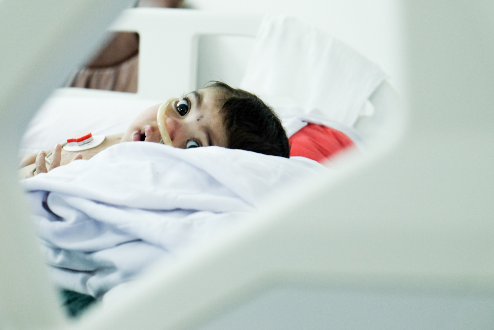 Baby Zahraa peering up from her hospital bed.