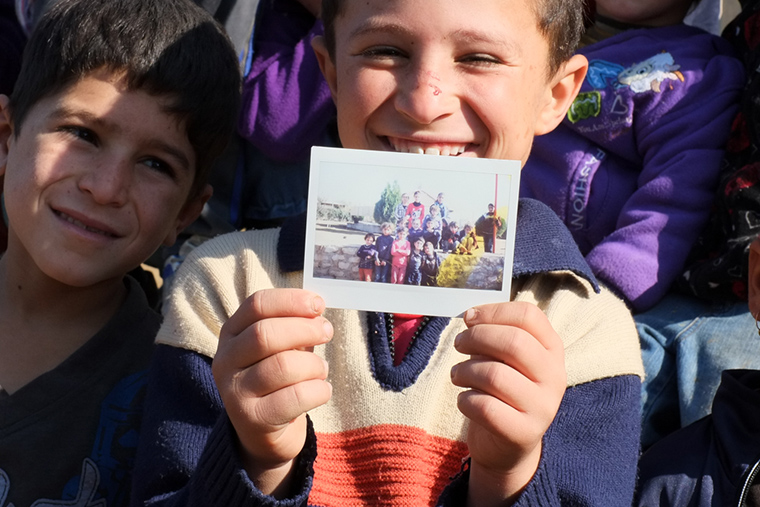 Instant photos go over well with the kids we serve. So many families displaced by ISIS no longer have any family photos, so it's a gift we love to give!