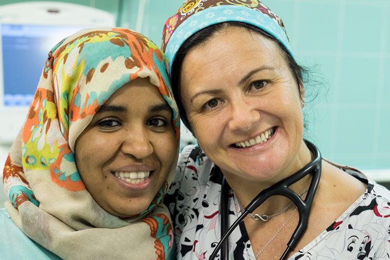 A local and an international nurse pose together at a hospital in Libya.