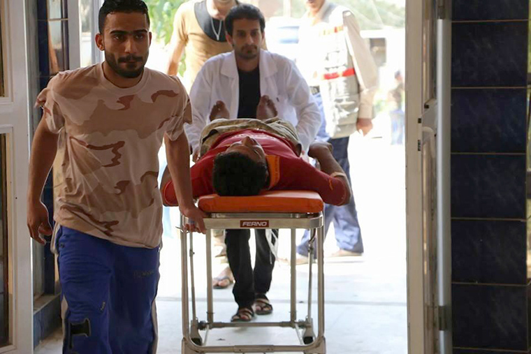 Dr. Mohammed wheels a wounded farmer into the hospital.