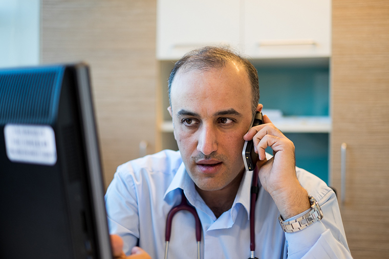 Dr. Firas on the phone with parents of his young patients, Faruq Medical Center, Iraq.