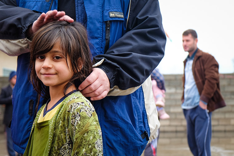A displaced Iraqi girl waits her turn to get a coat.