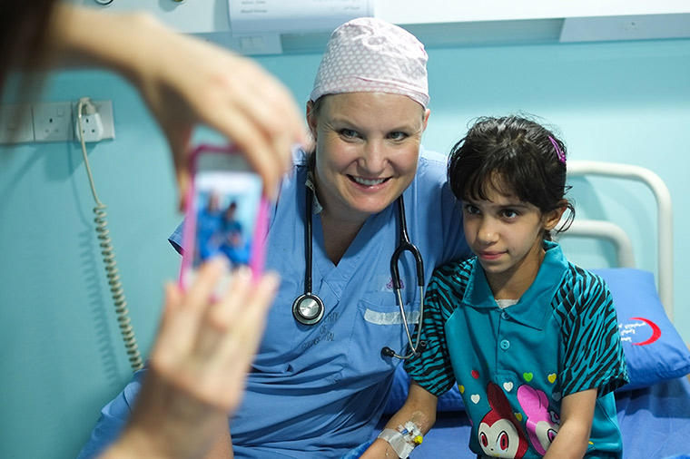 A nurse spends time with her patient, taking a photo with her to remember the moment.