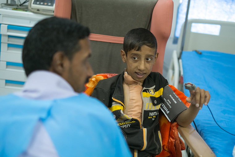 Ali and his father sit together after Ali's lifesaving heart surgery.
