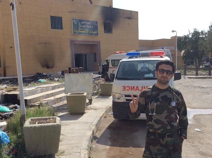 Dr. Mohammed standing in front of the hospital in Al Awja, previously controlled and burned out by ISIS.