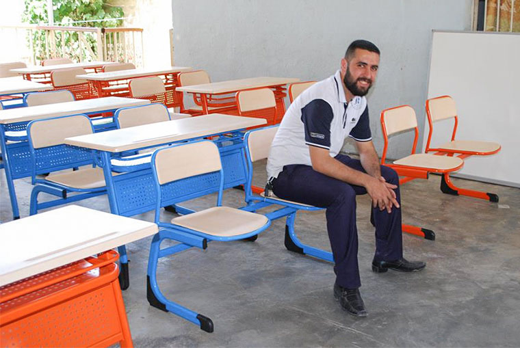 Staff from our partner organization Iraq Health Aid Organization takes a break after assembling desks.