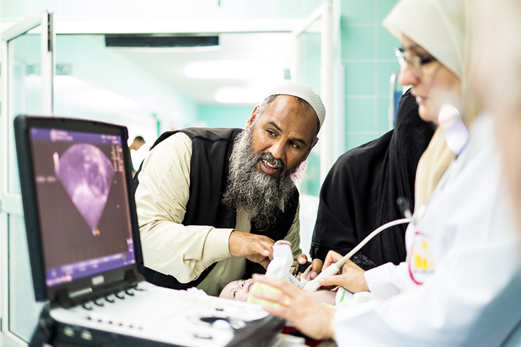 A pediatric cardiologist based in eastern Libya, checks a patient's heart.