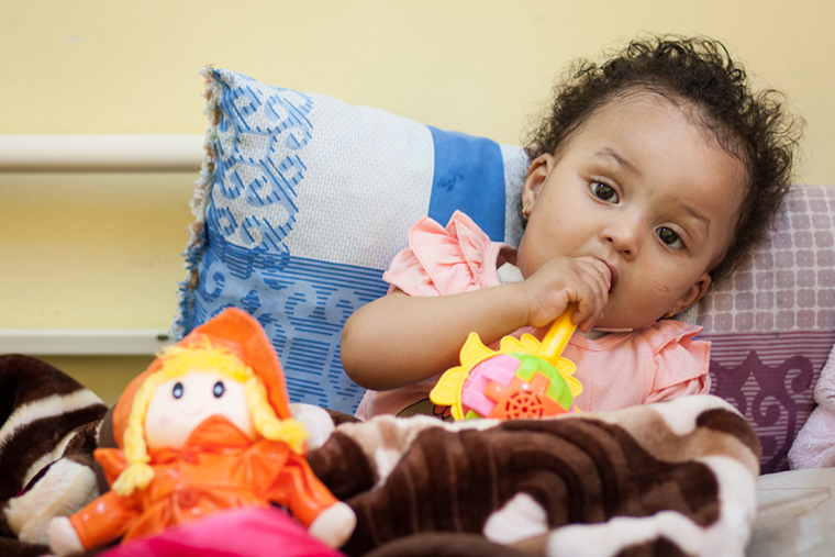 Tasnim sat on her bed, chewing the handle of her rattle, passing time until she was finally discharged from hospital following her lifesaving heart surgery.