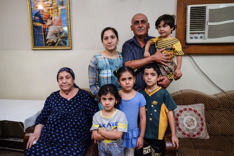 Isaac and his family pictured in their living room in Baghdad