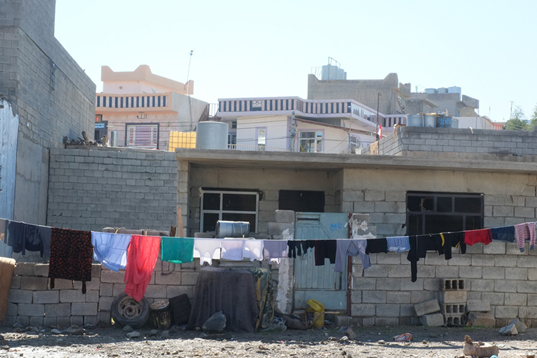 Laundry hangs in front of an unfinished, concrete block house in Kurdistan. Many of these unfinished houses have become homes to refugees from Syria and Iraqi families displaced by ISIS.