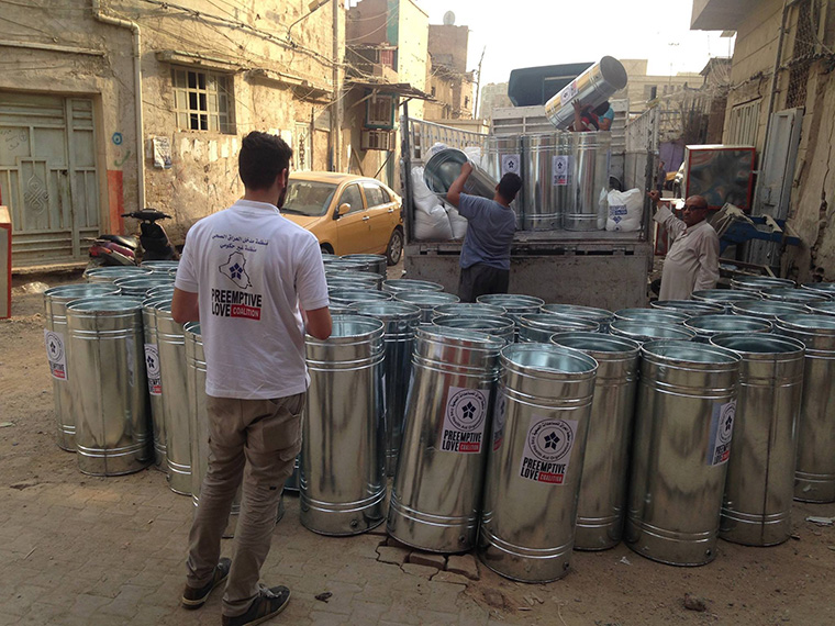 Water tanks being loaded onto a truck, to be delivered to Iraqi families trying to rebuild their lives.