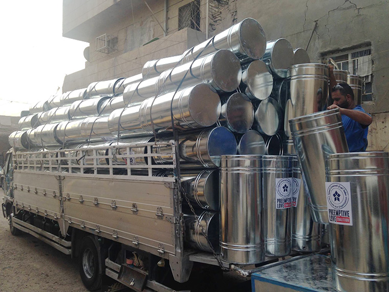 A truck loaded high with water tanks, destined for formerly displaced Iraqi families.