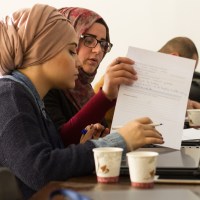 Two young women study in class.